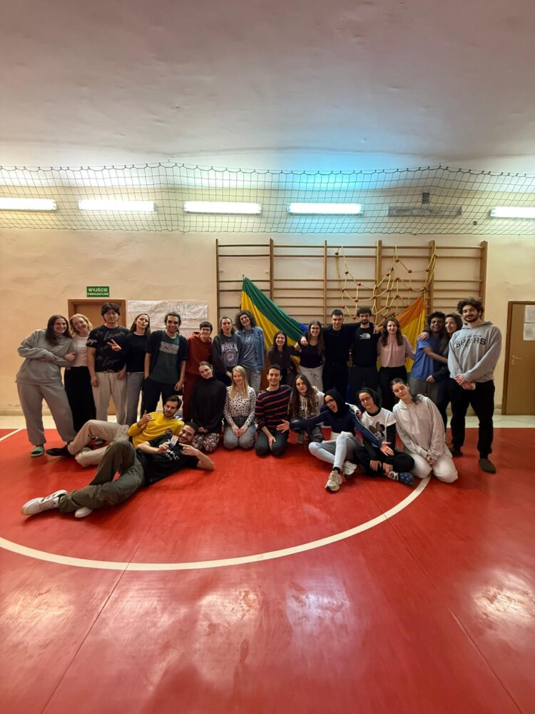 Skupina mladih (udeležencev mladinskega treninga), ki stojijo v dve vrsti, so dobre volje in so v pozi za fotografiranje.