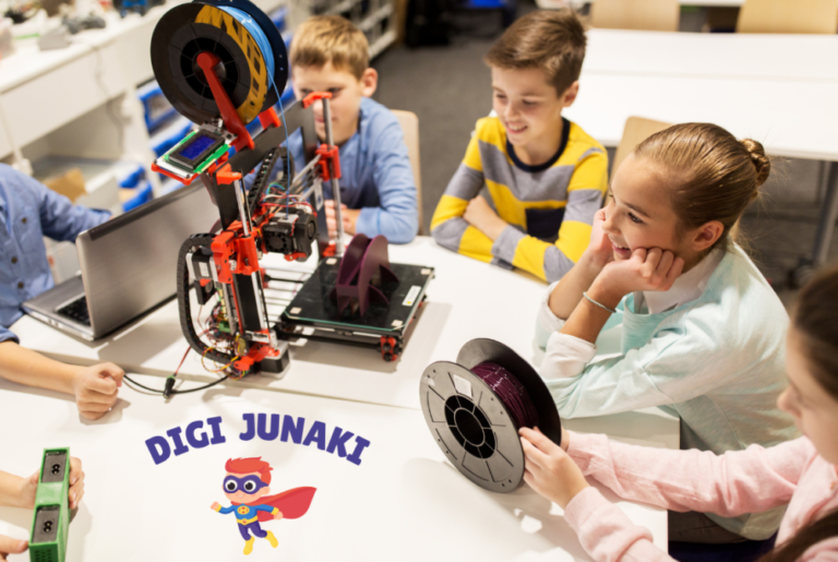 Fotografija otrok okoli 3d printera. Na sliki je napis DIGI JUNAKI, pod napisom je animirana slika superjunaka.