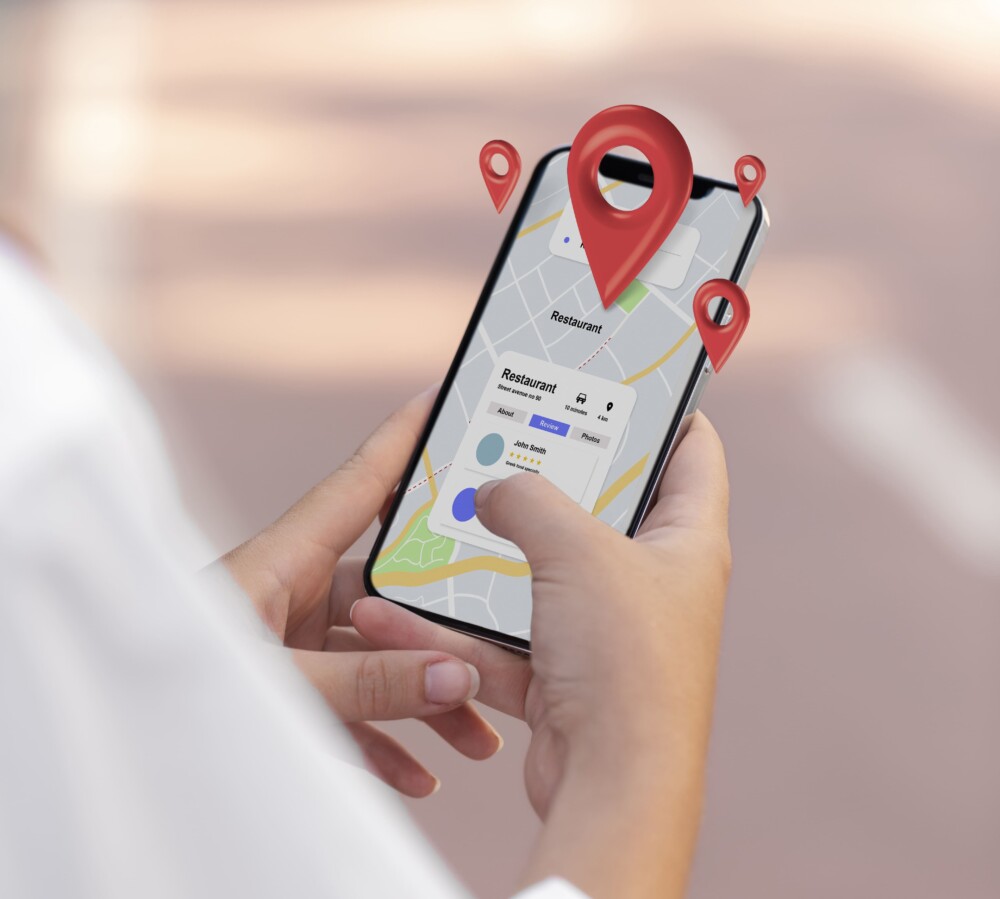 Na fotografiji je oseba, ki v rokah drži telefon in na Google zemljevidih išče pot.